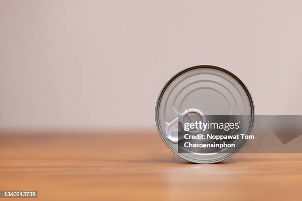 view of canned tuna on the side showing easy-opened end on wooden surface, bangkok, thailand - estaño fotografías e imágenes de stock