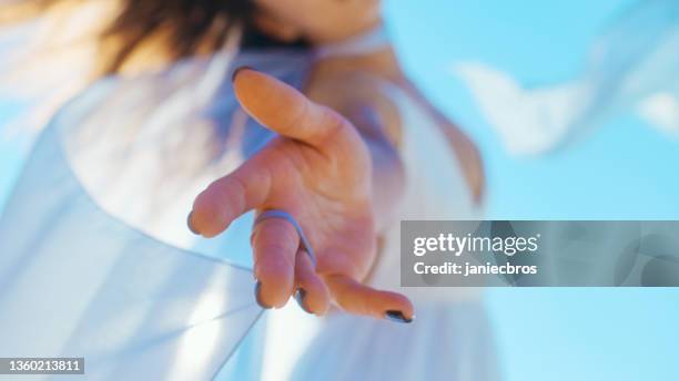 woman enjoying luxury silk dress, reaching towards camera. textile dancing with the wind - woman reaching hands towards camera stock pictures, royalty-free photos & images