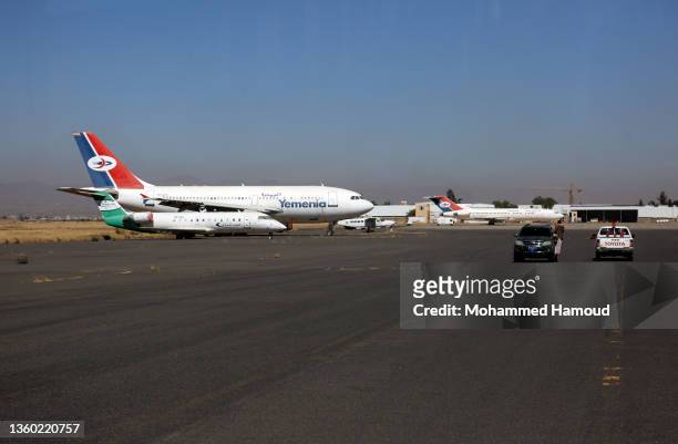 Employees of the Sana'a International Airport drive on the airport runway to inspect damage following aerial attacks by jet aircraft of the coalition...