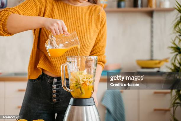 健康なスムージーを作る若い女性 - blended drink ストックフォトと画像