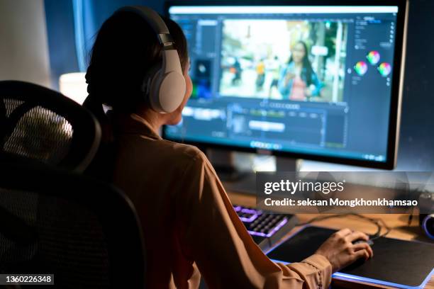 female video editor works with footage and sound on her personal computer. she works late. her office is modern and creative loft studio. - office space movie stock pictures, royalty-free photos & images