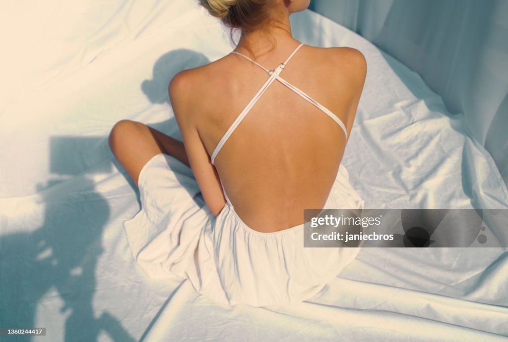 Brandneue Bilder für mein Profil. Frau posiert in verführerischem Kleid mit nacktem Rücken