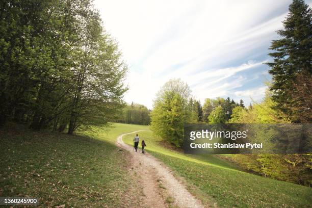 mother with daughter trekking on mountain meadow - distant family stock pictures, royalty-free photos & images