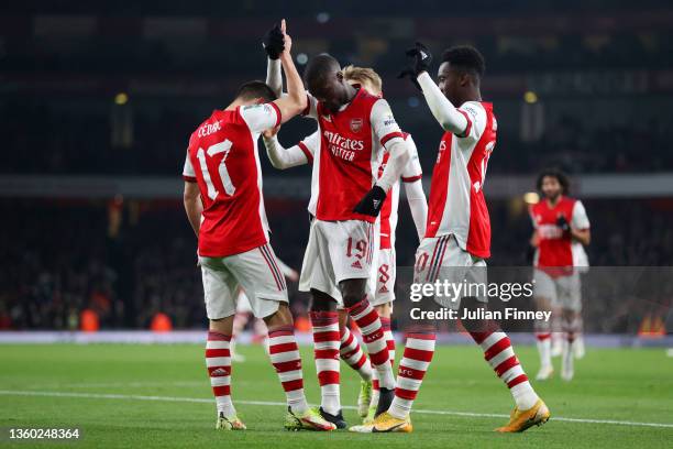 Nicolas Pepe of Arsenal celebrates with teammates Cedric Soares and Eddie Nketiah of Arsenal after scoring their team's second goal during the...