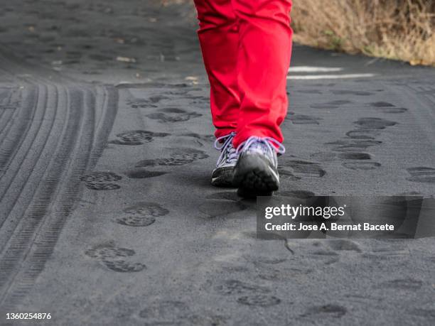 street with the footprints of a person walking on the volcanic ash from the eruption of the cumbre vieja volcano on the island of la palma. - cinerea foto e immagini stock