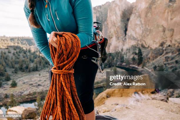 close up of a female rock climber coiling a rope at the base of a rock face in smith rock - smith rock state park fotografías e imágenes de stock