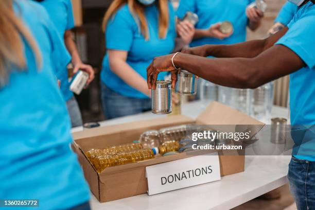 volunteers packing groceries in boxes for donations - philanthropist stock pictures, royalty-free photos & images