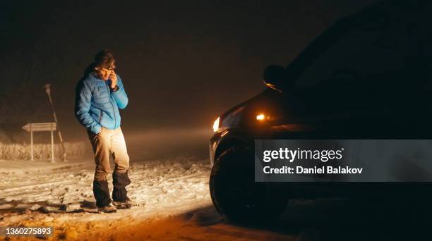 mann mit autoproblemen auf der winterstraße, anruf um hilfe. - winter panne auto stock-fotos und bilder