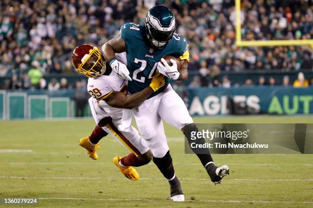 Jeremy Reaves of the Washington Football Team tackles Jordan Howard of the Philadelphia Eagles during the second quarter at Lincoln Financial Field...