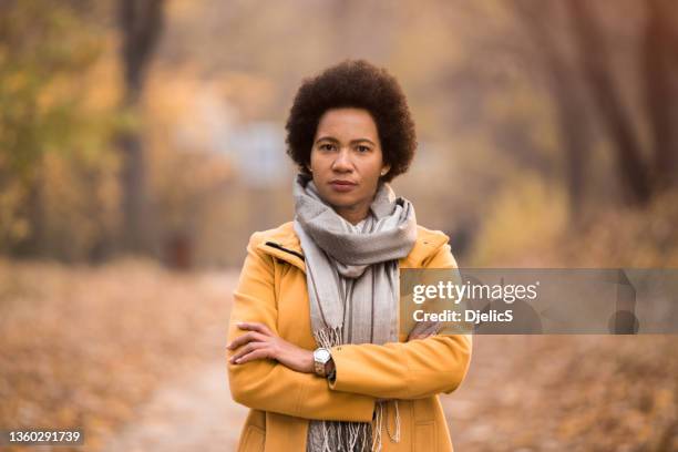 portrait of african american woman looking at camera on autumn day. - season 42 stock pictures, royalty-free photos & images