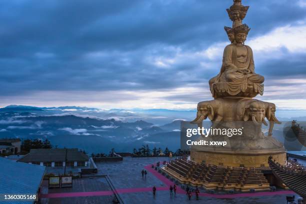 statue of samantabhadra bodhisattva(puxian bodhisattva) on the golden summit of mount emei, sichuan, china.  statue of puxian bodhisattva with golden roof on mount emei, sichuan, china - emei shan stockfoto's en -beelden