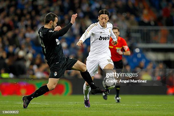 Mesut Ozil of Real Madrid duels for the ball with Samuel San Jose of Ponferradina during the round of last 16 Copa del Rey second leg match between...