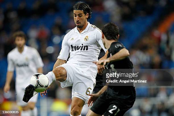 Sami Khedira of Real Madrid controls the ball beside David Malo of Ponferradina during the round of last 16 Copa del Rey second leg match between...