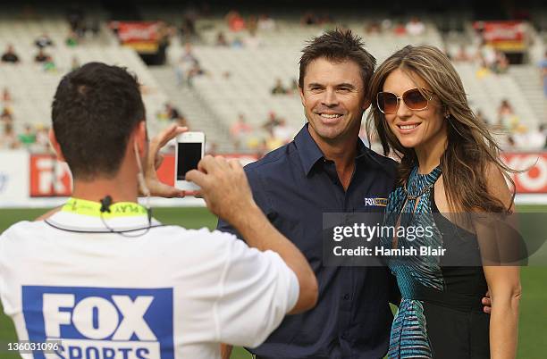 Liz Hurley poses with former cricketer and Fox Sports presenter Greg Blewett during the T20 Big Bash League match between the Melbourne Stars and the...