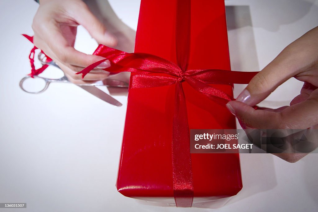 A seller wraps a gift in a Parisian depa