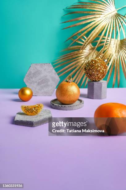 christmas creative bright composition with tangerines, concrete podiums and golden palm leaves. - glitter fruit stock pictures, royalty-free photos & images