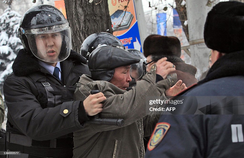 Kazakh riot policeman detain an oppositi