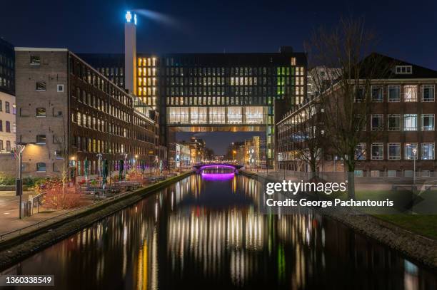 amsterdam university building at night - fluss amstel stock-fotos und bilder