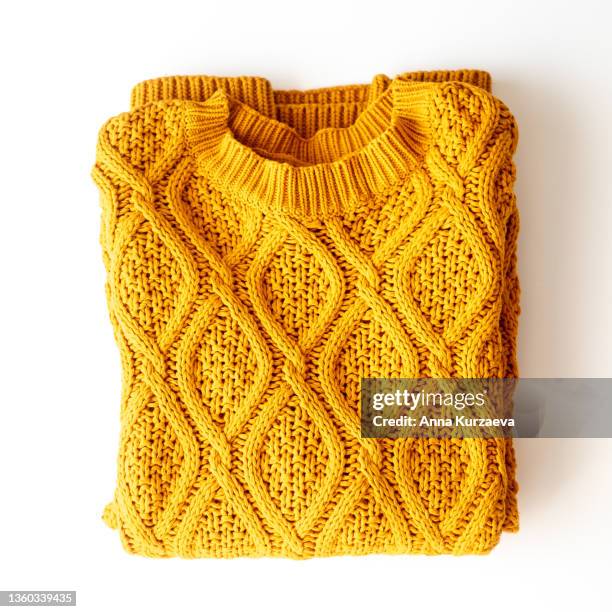 folded yellow sweater on a table, top view - woolly hat stock-fotos und bilder