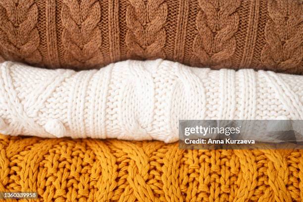 stack of folded sweaters on a table, selective focus - cardigan sweater stock pictures, royalty-free photos & images