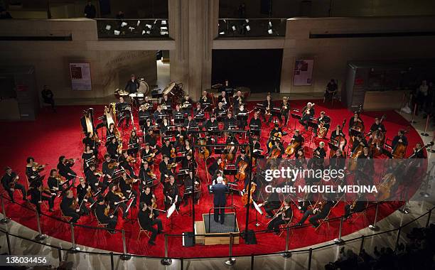 French composer and conductor Pierre Boulez directs the Paris Orchestra under the Louvre Pyramid during a free concert on December 21, 2011 in Paris....
