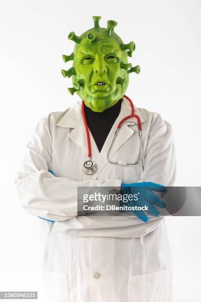man dressed as green coronavirus with a latex mask, doctor's gown and latex gloves, on white background. concept of covid-19, delta variant, omicron variant, pandemic and quarantine. - doctor humor stock pictures, royalty-free photos & images