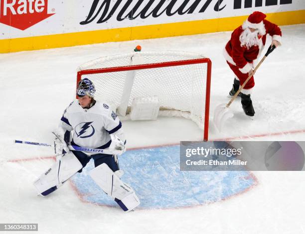 Andrei Vasilevskiy of the Tampa Bay Lightning stands in front of the net as a member of the Knights Guard dressed as Santa Claus cleans the ice...