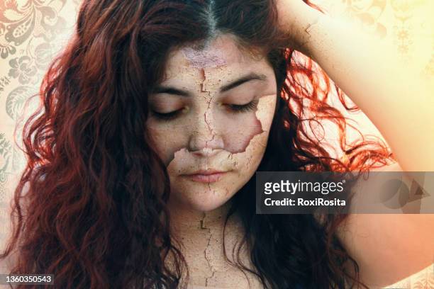 close-up of a woman looking down with dry skin peeling off. dehydrated skin concept. - peel off mask stock-fotos und bilder
