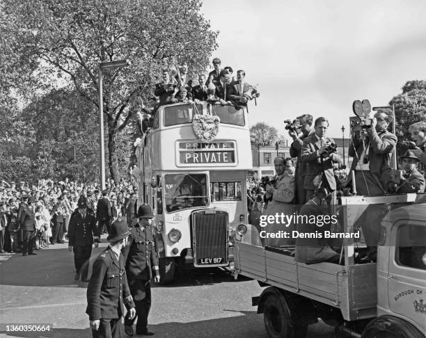 Tottenham Hotspur Football Club players standing in a Leyland Titan PD1/1 open top double decker bus registration LEV 917 wave to their fans while...