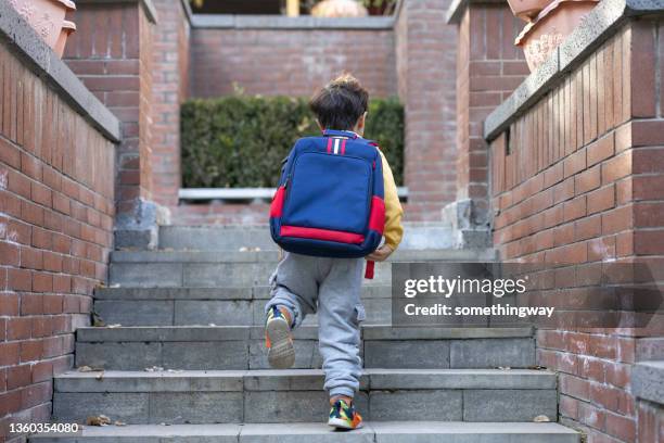 a little boy coming home from school - coming back stock pictures, royalty-free photos & images