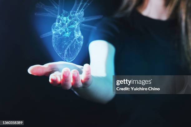 woman and heart hologram - human heart fotografías e imágenes de stock