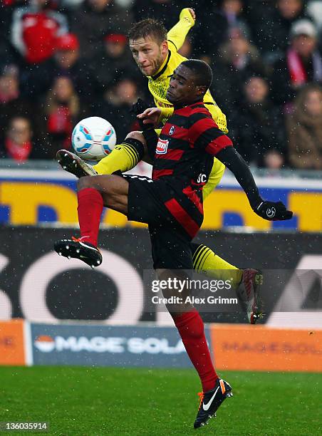 Cedric Makiadi of Freiburg is challenged by Jakub Blaszczykowski of Dortmund during the Bundesliga match between SC Freiburg and Borussia Dortmund at...