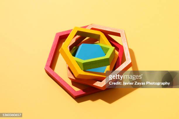 multi colored hexagons jigsaw puzzle on yellow background - mismatch fotografías e imágenes de stock