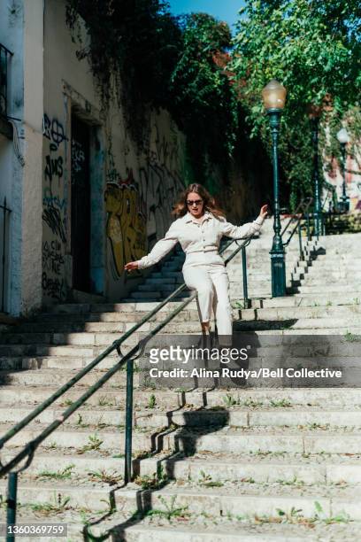 young woman sliding down a stair railing - osteuropäischer abstammung stock-fotos und bilder