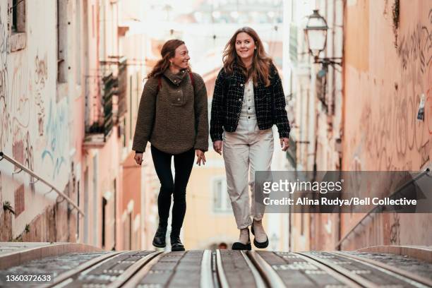 Two female friends walking up the street