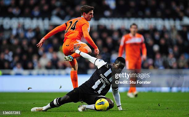 Swansea player Joe Allen is challenged by Cheick Tiote during the Barclays Premier league game between Newcastle United and Swansea City at St James'...