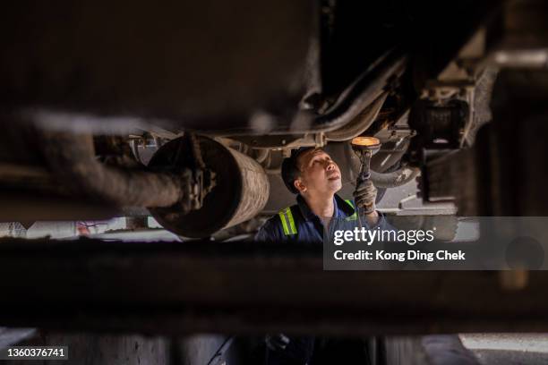 asian chinese mechanic checking truck chassis in the repair shop - commercial land vehicle stock pictures, royalty-free photos & images