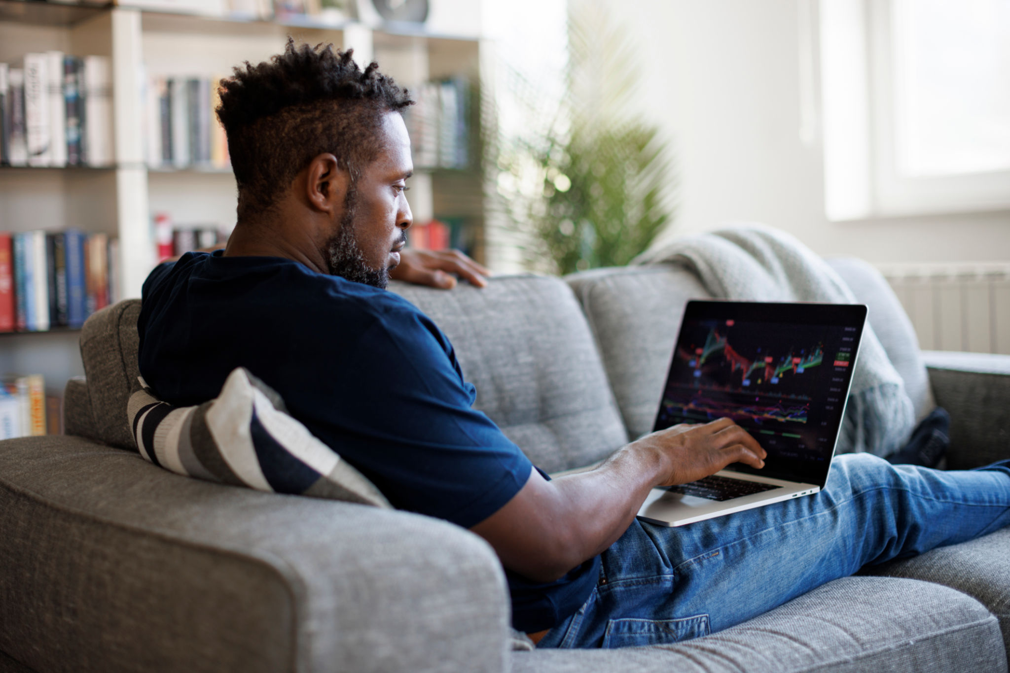 Man analyzing stock market with charts on laptop computer screen at home Man analyzing stock market with charts on laptop computer screen at home