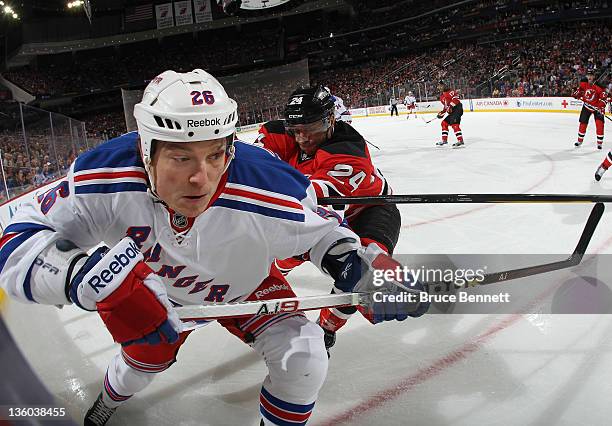 Bryce Salvador of the New Jersey Devils checks Ruslan Fedotenko of the New York Rangers at the Prudential Center on December 20, 2011 in Newark, New...