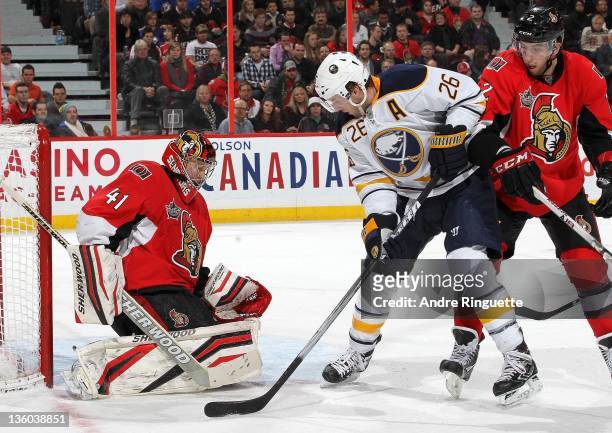 Thomas Vanek of the Buffalo Sabres creates a screen against Craig Anderson and Jared Cowen of the Ottawa Senators as the puck trickles into the net...