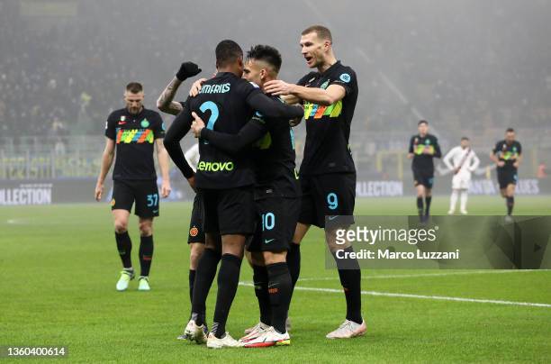Denzel Dumfries of FC Internazionale celebrates with teammates Edin Dzeko and Lautaro Martinez after scoring their side's first goal during the Serie...