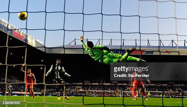 Swansea goalkeeper Michel Vorm dives at a shot by Demba Ba during the Barclays Premier league game between Newcastle United and Swansea City at St...