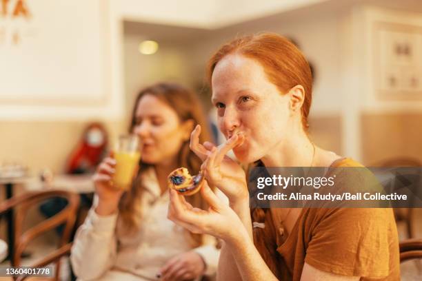 two female friends are having coffee and desert in a portuguese coffee shop - pastel de nata stock pictures, royalty-free photos & images