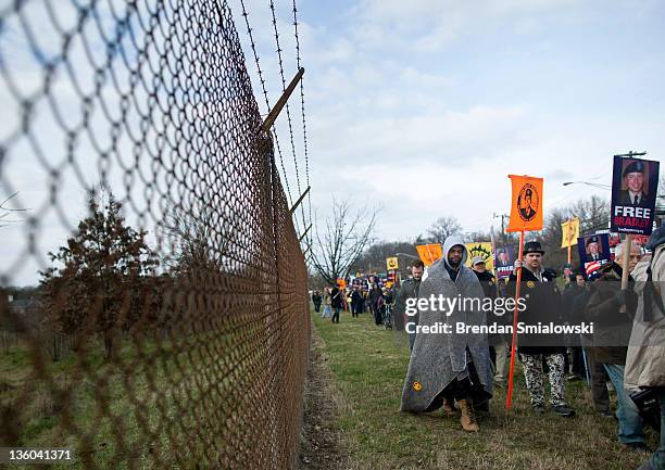 Protesters march along the fence line at Fort Meade December 17, 2011 in Fort Meade, Maryland. An Article 32 hearing for Army Pfc. Bradley Manning is...