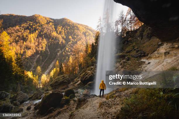 one person standing behind a waterfall - slovenia hiking stock pictures, royalty-free photos & images