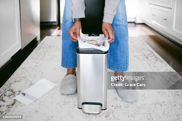 woman removes trash bag from can - bin ストックフォトと画像