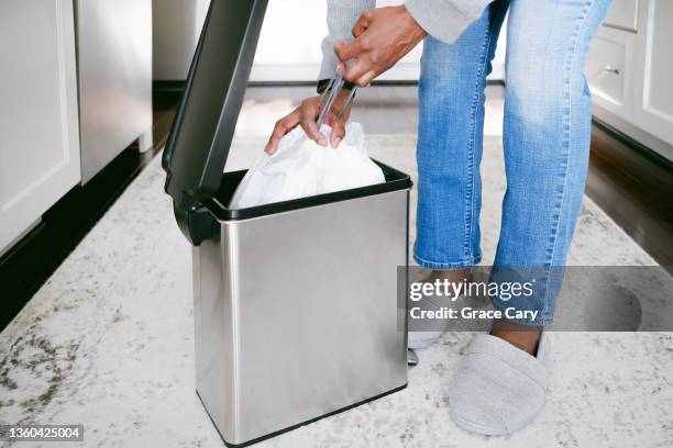 woman removes trash bag from can - garbage bin stock pictures, royalty-free photos & images