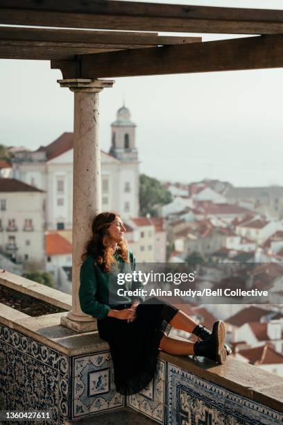 young woman relaxing on a tiled balcony of an observation deck in alfama, lisbon - lisbon tourist stock pictures, royalty-free photos & images