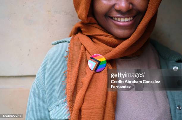 a smiling muslim woman wearing a lgbtq pin on her clothing - religion bildbanksfoton och bilder