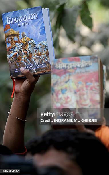 Protesters belonging to the Vishwa Hindu Parishad -- World Hindu organisation, hold a copy of the of one of Hinduism's most important and scared...